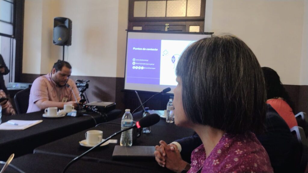 Imagen de varios participantes a la mesa parlamentaria, en primer plano Silvia Quan y al fondo la pantalla que utlizaron para las presentaciones