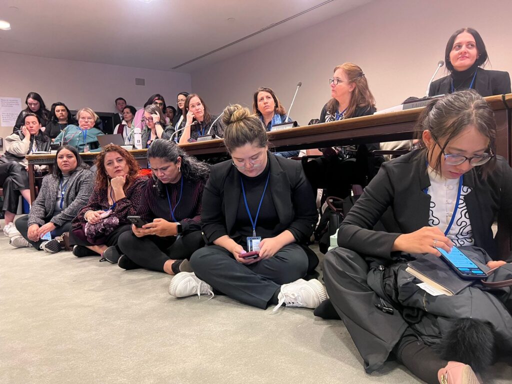 Fotografia de algunas participantes de la reunión CSW 2024. En la imagen se ven personas sentadas incluso en el suelo
