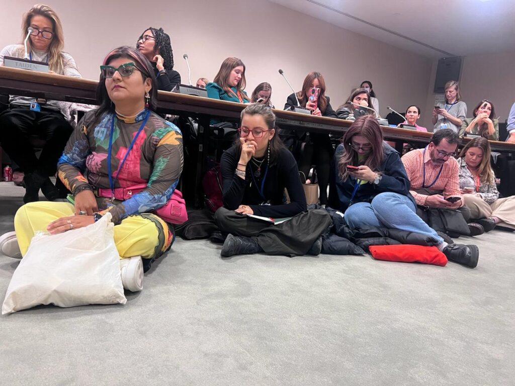 Fotografia de algunas participantes de la reunión CSW 2024. En la imagen se ven personas sentadas incluso en el suelo